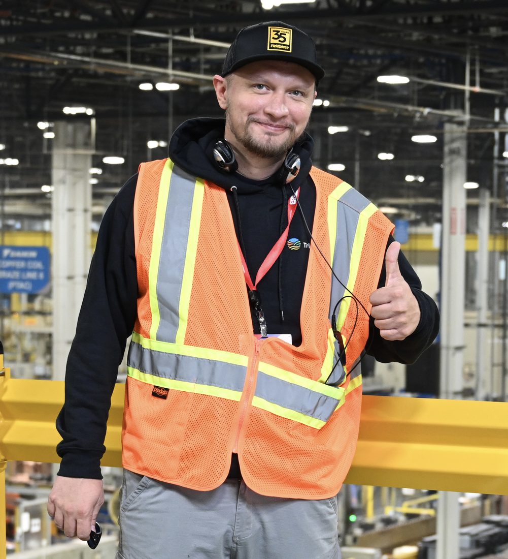 Andrew Kuznetsov, owner of Bay Area Appliance Repair Service, in a safety vest on the factory floor during manufacturer HVAC training